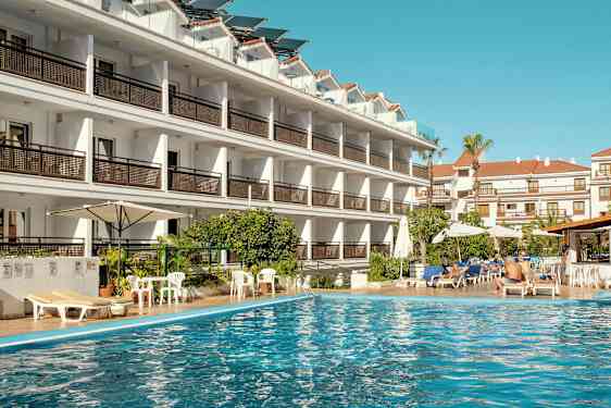 Hotellbyggnad vid en swimmingpool. (AI-genererad text)