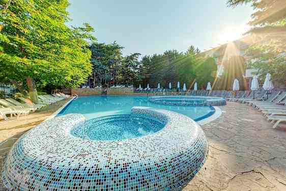 Utomhuspool med solstolar och träd i bakgrunden. (AI-genererad text)