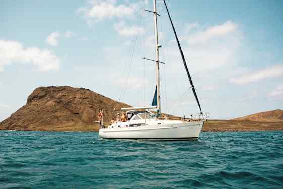 Segelbåt på vatten med berg i bakgrunden. (AI-genererad text)