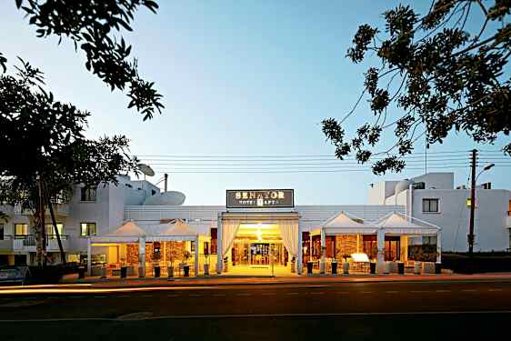 Entrén till Senator Hotel Apartments med kvällsbelysning. (AI-genererad text)