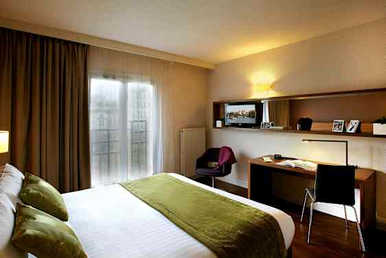 Hotellrum med dubbelsäng och arbetsbord. (AI-genererad text)