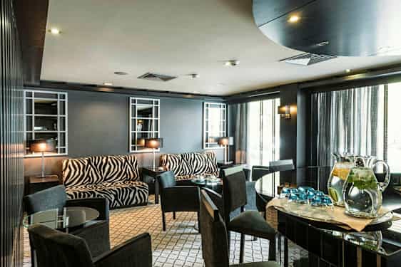 Ett rum med möbler i zebramönster och glasbord. (AI-genererad text)