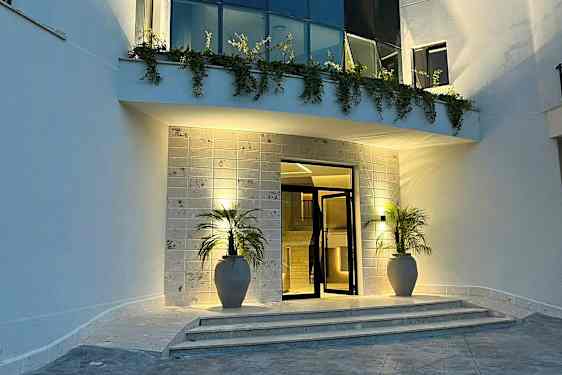 Entré med två krukor, trappsteg och belysning på kvällen. (AI-genererad text)