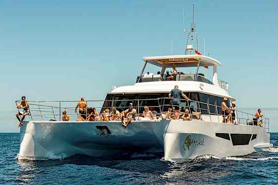 En vit motorbåt på havet med människor som njuter av solen. (AI-genererad text)