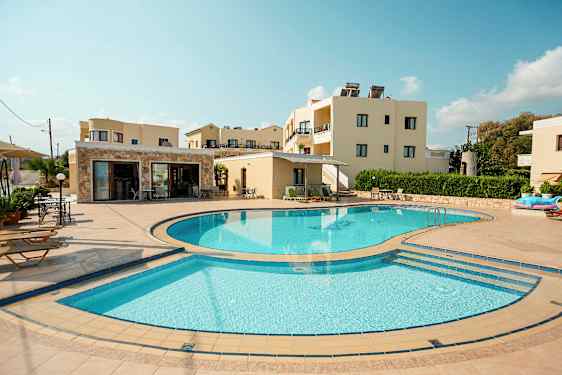 En bild som visar en utomhuspool omgiven av solstolar och byggnader i bakgrunden. (AI-genererad text)