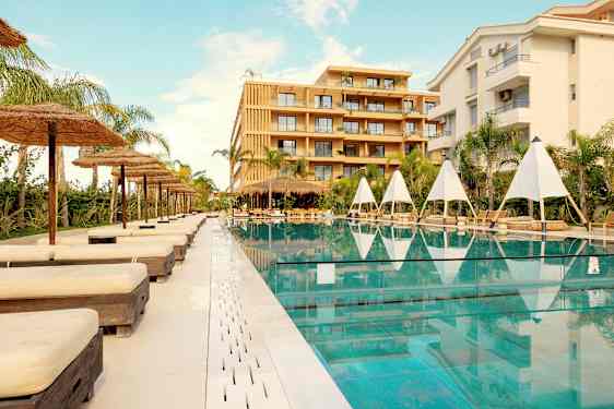 Utomhuspool med solstolar och parasoller vid ett hotell. (AI-genererad text)