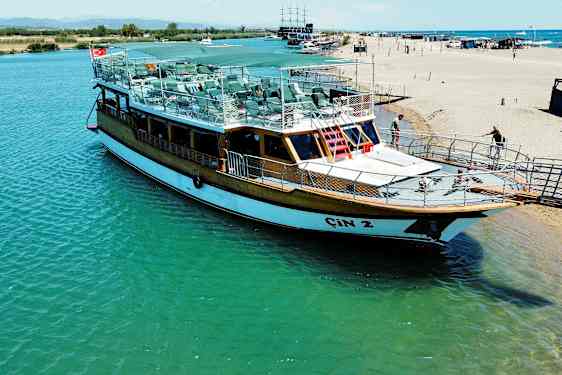 En båt ligger vid en brygga nära stranden. (AI-genererad text)