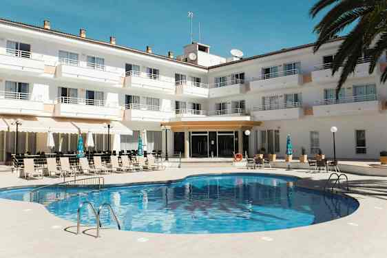 En pool framför en hotellanläggning med solstolar och parasoller. (AI-genererad text)