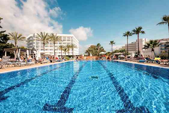 Utomhuspool vid hotell med solstolar och palmer. (AI-genererad text)