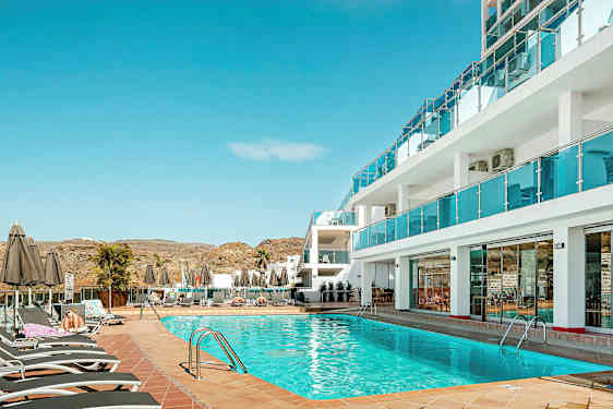 Poolområde vid hotell med solsängar och parasoller. (AI-genererad text)