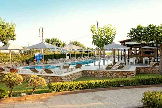 En pool omgiven av solstolar, parasoller och grönska. (AI-genererad text)