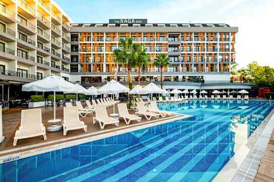 Ett hotell vid en pool med solstolar och parasoller. (AI-genererad text)