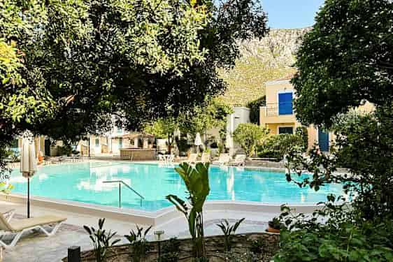 Bild av en pool omgiven av träd och solstolar. (AI-genererad text)