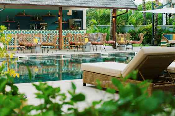 Bild av en poolområde med solstolar och en bar i bakgrunden. (AI-genererad text)