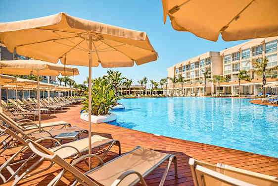 Poolområde med solstolar och parasoller på en terrass av trä. (AI-genererad text)