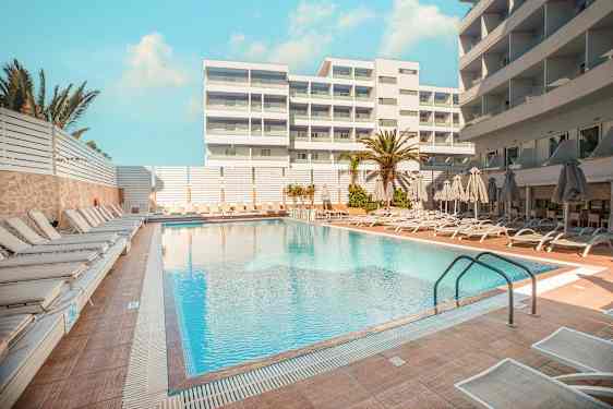 Hotellpool med solsängar och parasoller på omgivande terrass. (AI-genererad text)