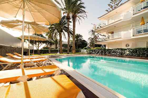 Utomhuspool med solstolar och parasoller i soligt väder. (AI-genererad text)