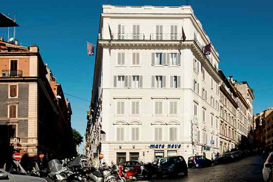 En gata med bilar och motorcyklar framför byggnader i stadsområdet. (AI-genererad text)