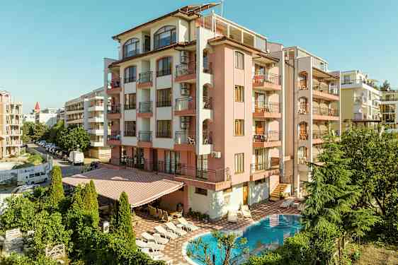 Byggnad med rosa fasad, balkonger och en pool framför. (AI-genererad text)