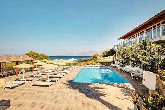 En pool med solstolar och parasoller på en terrass med utsikt över havet. (AI-genererad text)