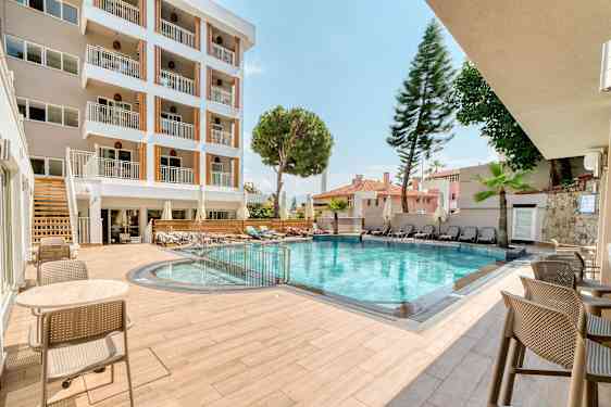 Hotellets utomhuspool med sittmöbler och solstolar. (AI-genererad text)