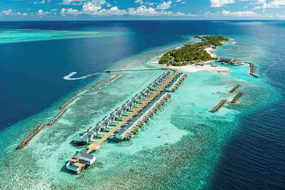 Flygfoto av en tropisk ö med strandvillor i vatten och omgivande turkost hav. (AI-genererad text)