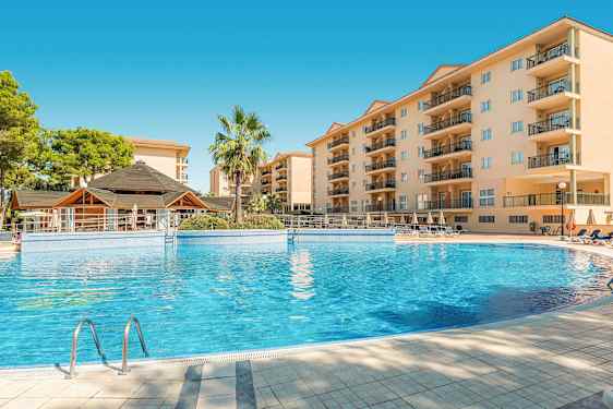 Bild på en hotellpool med omgivande byggnader och en palm. (AI-genererad text)