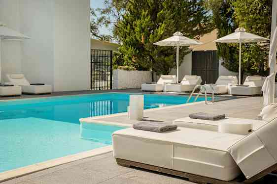 Utomhuspool med solsängar och parasoller. (AI-genererad text)