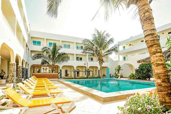 Uteområde med pool, solstolar och omgivande byggnader. (AI-genererad text)