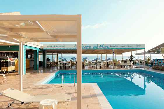 Bild av en pool vid en terrass med restauranger vid havet. (AI-genererad text)