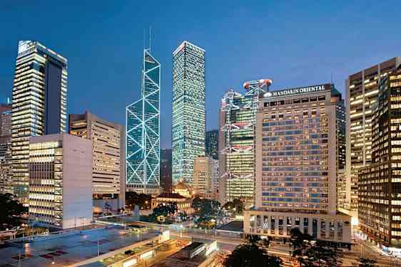 Stadsvy med höga byggnader upplysta i kvällsljus. (AI-genererad text)