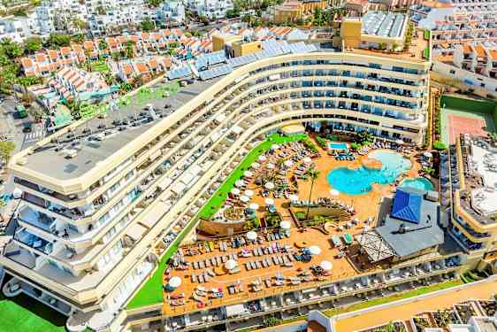 Bild av ett hotell med poolområde och omgivande semesterbostäder. (AI-genererad text)