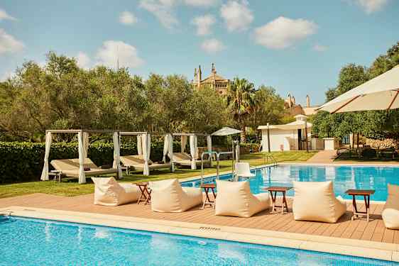 Utomhuspool med solstolar och parasoll, omgiven av grönska. (AI-genererad text)