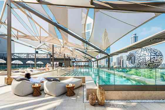 En modern utomhuspool med sittplatser och utsikt över stadens skyline. (AI-genererad text)