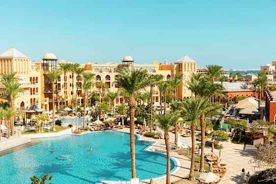 Hotellområde med pool och palmer. (AI-genererad text)