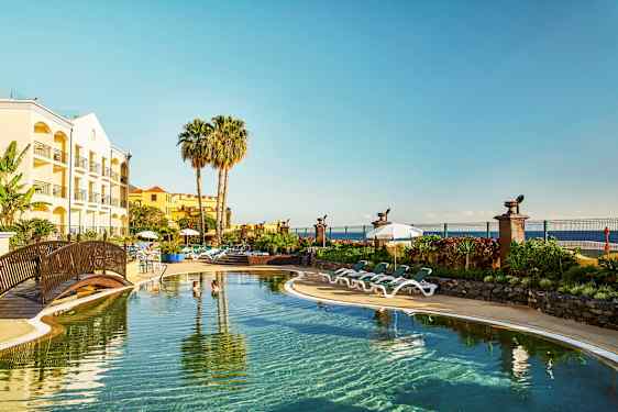 Hotell med pool, solstolar och palmträd vid kusten. (AI-genererad text)