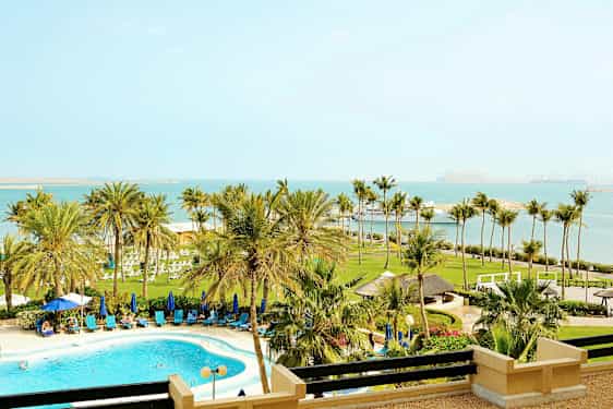 Bild av en strandresort med pool, palmer och havsutsikt. (AI-genererad text)