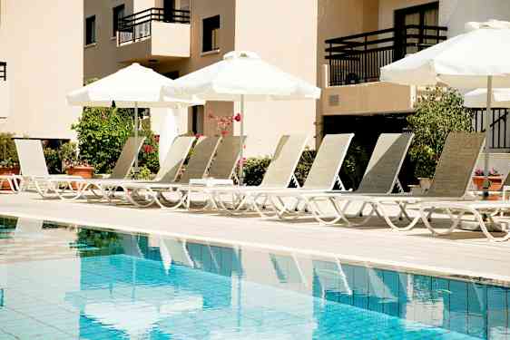 Solstolar vid en pool med parasoller. (AI-genererad text)