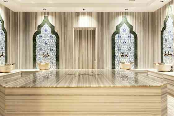Hamam-rum med mosaikväggar och marmorbänk. (AI-genererad text)