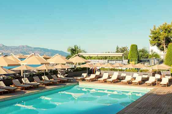 En utomhuspool omgiven av solstolar och parasoller. (AI-genererad text)