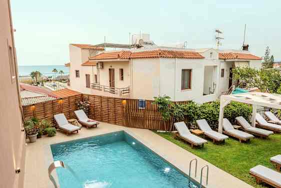 Utomhuspool med solstolar och omgivande byggnader i bakgrunden. (AI-genererad text)