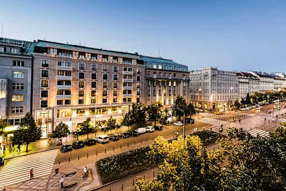 En stadsvy med byggnader, ett torg, belysning och träd. (AI-genererad text)