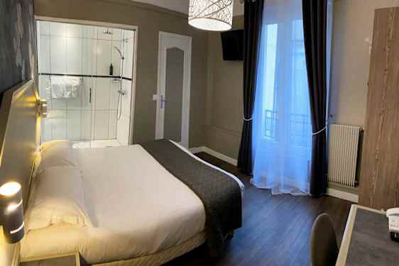 En hotellrum med en säng, ett skrivbord och en dusch. (AI-genererad text)