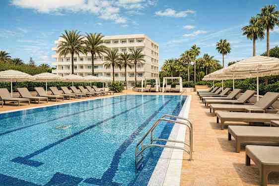 En hotellpool omgiven av solstolar och parasoller med en byggnad i bakgrunden. (AI-genererad text)