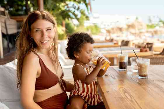 Dotter sitter hos sin mamma och dricker juice
