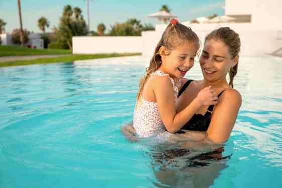 Mamma och dotter i pool