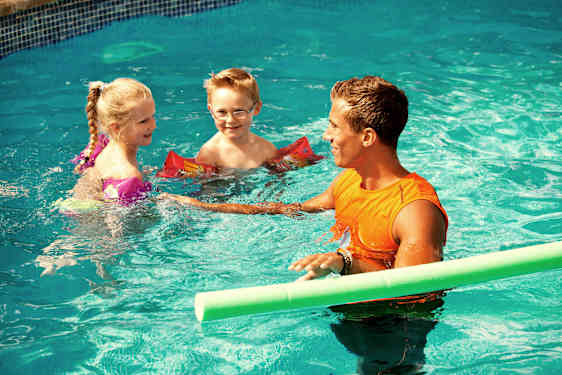 pojke och pappa framför poolen