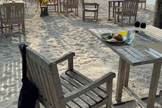 Bord och stolar på strand i morgonsol