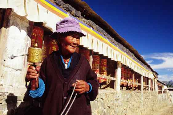 Tibetansk kvinna med bönesnurra i Tashilhunpo