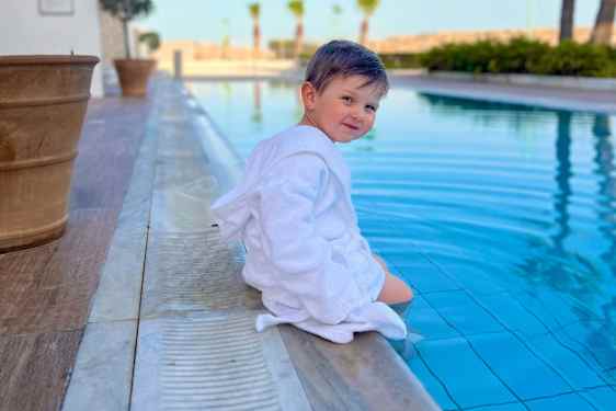 Barn sitter vid poolen